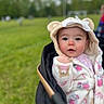 baby, child, hood, coat, stroller, outdoor, grass, field, face, cute, infant, warm_clothing, pink, white, animal_ears, portrait, young_child, expression, nature, daytime