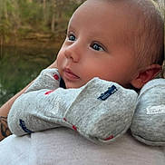 Landen joined the competition — help win amazing prizes! baby, close_up, cute, face, grey_clothing, head, human, infant, looking_away, mittens, nature, newborn, outdoor, person, portrait, soft_lighting, trees, warm_clothing, water, young_child