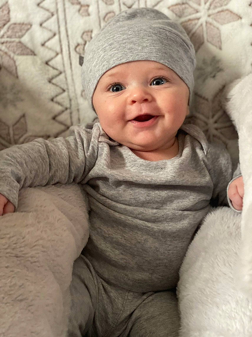 Liam is registered to the contest to win money with this photo: baby, baby_toddler_clothing, cap, cheek, comfort, eye, face, happy, head, headgear, headwear, lip, nose, organ, outerwear, person, photograph, skin, sleeve, smile