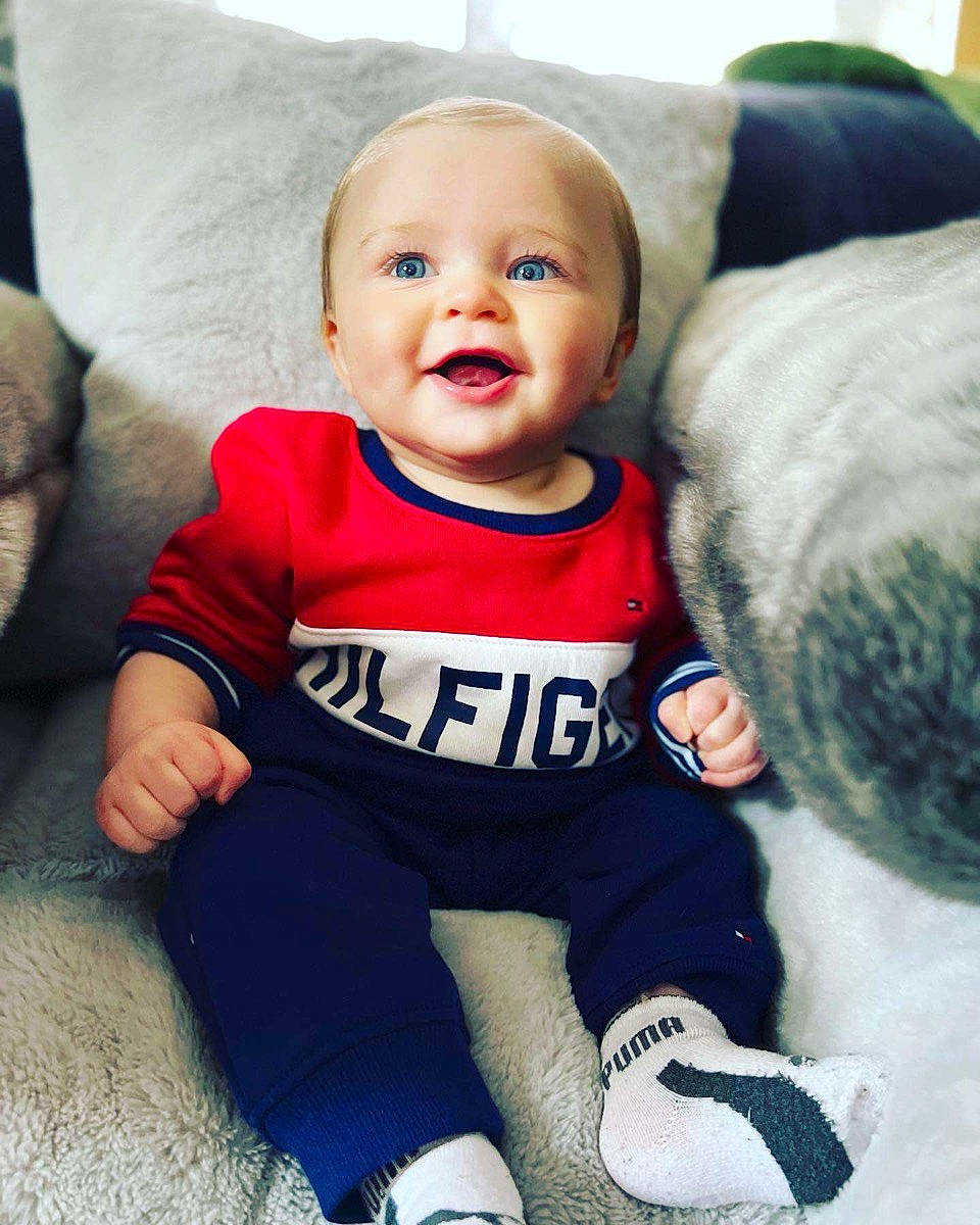 Liam joined the competition — help win amazing prizes! baby, baby_products, baby_toddler_clothing, child, comfort, couch, electric_blue, face, fun, fur, happy, linens, person, sitting, sleeve, smile, sportswear, t_shirt, textile, throw_pillow