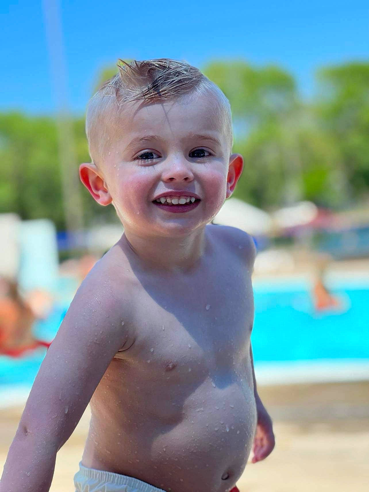 Kennedy is registered to the contest to win money with this photo: abdomen, barechested, chest, child, chin, eye, face, fun, happy, joy, leisure, lip, neck, people_on_beach, person, skin, sky, smile, swimwear, toddler