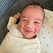 Owen participe au concours pour gagner de l'argent avec cette photo : baby, smiling, infant, cozy, face, cheeks, lying_down, clothing, soft_texture, happy, cute, child, skin, expression, indoors, blanket, pattern, head, portrait, young