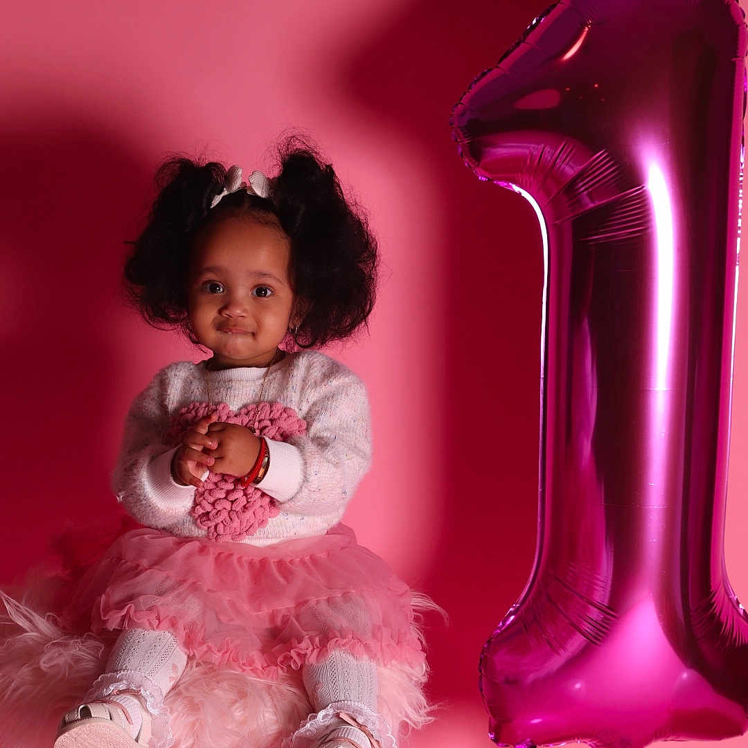 Sileyni is registered to the contest to win money with this photo: accessories, baby, balloon, bodypart, clothing, couch, dress, face, finger, footwear, furniture, hand, head, highheel, person, purple, shoe, sphere, text, toy