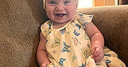 Vienna joined the competition — help win amazing prizes! baby, child, smiling, dress, headband, bow, butterfly_pattern, couch, indoor, happy, person, infant, sitting, sunlight, warm_light, cute, portrait, fabric, furniture, skin