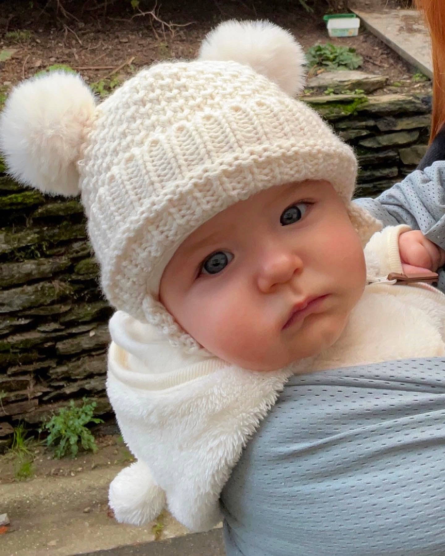 Victoire a rejoint le concours — aidez-le/la à gagner de superbes lots ! baby, baby_toddler_clothing, beanie, cap, cheek, child, eye, fashion_accessory, fur, grass, headgear, headwear, knit_cap, lip, pattern, person, sitting, skin, toddler, winter