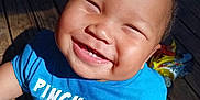 Zaedyn joined the competition — help win amazing prizes! baby, smiling, child, blue_shirt, outdoor, sunlight, wooden_deck, cute, happy, teeth, face, sitting, infant, clothing, person, playful, daylight, skin, expression, toddler