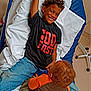 Samuel is registered to the contest to win money with this photo: child, children, hospital_bed, smiling, boy, casual_clothing, jeans, tshirt, curly_hair, playful, medical_wristband, indoor, hospital_room, toy, candid, happy, person, bed, healthcare, care
