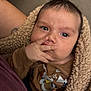 baby, infant, blanket, brown_clothing, hand, face, eyes, fingers, cozy, cute, indoor, person, portrait, newborn, child, soft_texture, snug, toddler, expression, candid