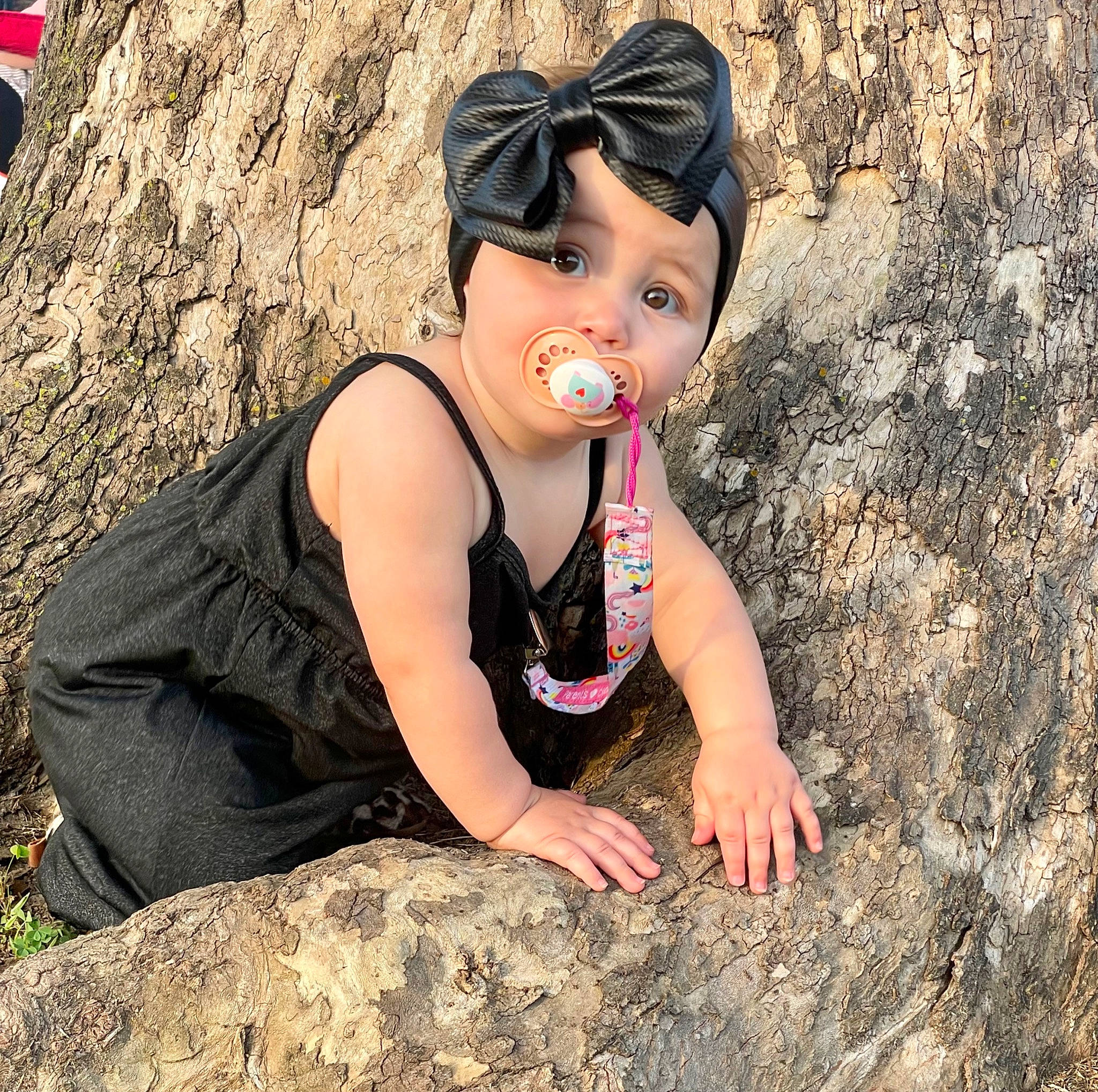 Evie joined the competition — help win amazing prizes! baseball_cap, black_hair, cap, eye, flash_photography, fun, grass, happy, hat, headwear, human_leg, landscape, leisure, long_hair, people_in_nature, person, plant, sitting, thigh, tree