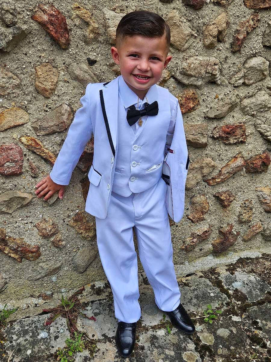 Dayron a rejoint le concours — aidez-le/la à gagner de superbes lots ! blazer, bow_tie, child, collar, dress, dress_shirt, electric_blue, footwear, formal_wear, gesture, grass, happy, joy, people_in_nature, person, sleeve, smile, suit, textile, toddler