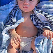 Judah is registered to the contest to win money with this photo: baby, infant, child, diaper, blanket, towel, striped_clothing, face, eyes, hair, hands, feet, stroller, sunlight, outdoor, portrait, blanket_wrap, candid, relaxed, cute