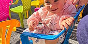 Thalia participe au concours pour gagner de l'argent avec cette photo : toddler, child, smiling, blue_chair, plastic_chair, headband, pink_jacket, outdoor, colorful_chairs, yellow_chair, orange_chair, pink_chair, socks, gravel_ground, daylight, person, hand, event, happy, casual_clothing