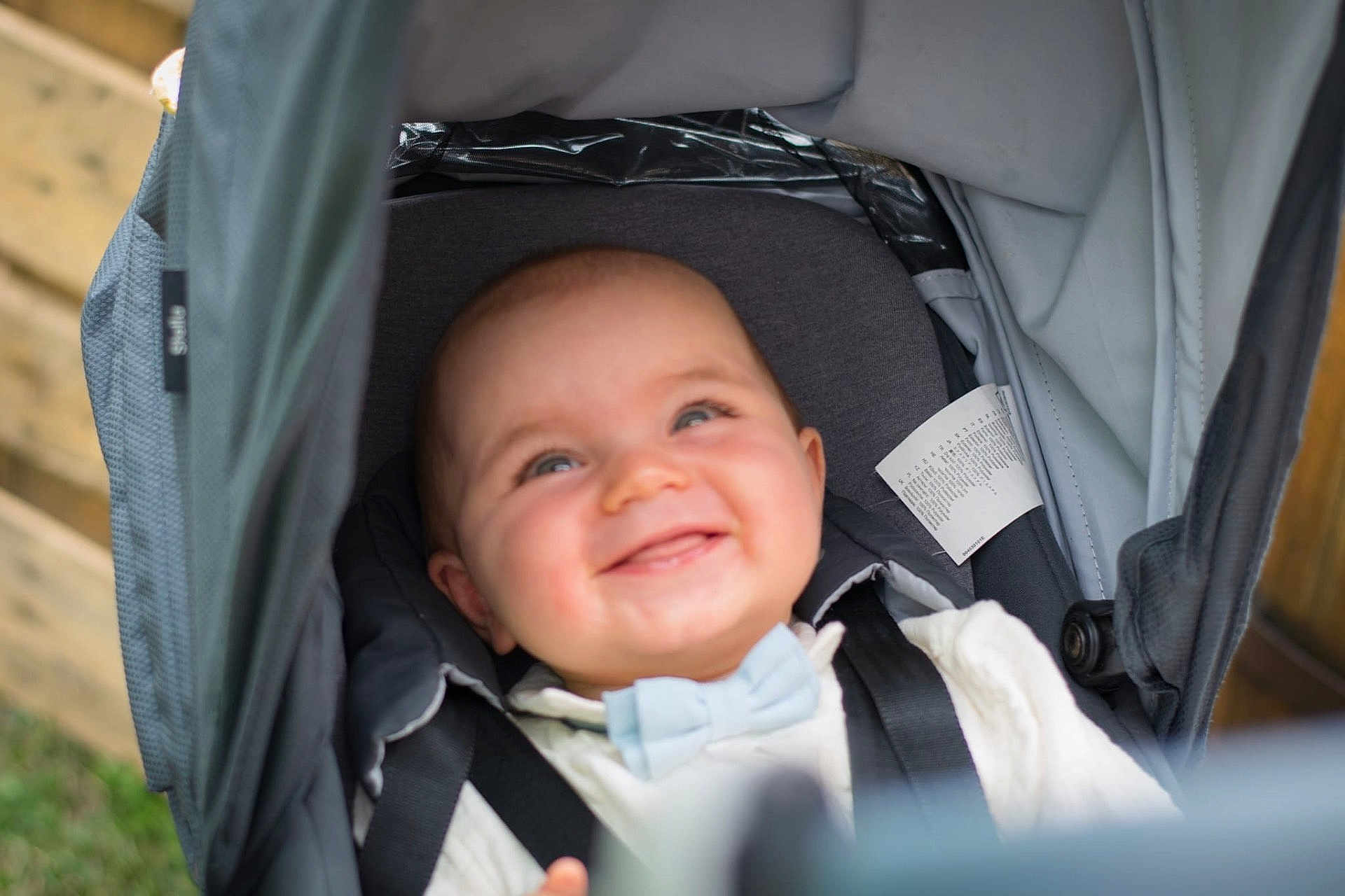 Léo a rejoint le concours — aidez-le/la à gagner de superbes lots ! baby, smiling, stroller, bow_tie, child, happy, infant, seatbelt, outdoor, fabric, canopy, closeup, cute, portrait, person, clothing, head, baby_boy, face, seat
