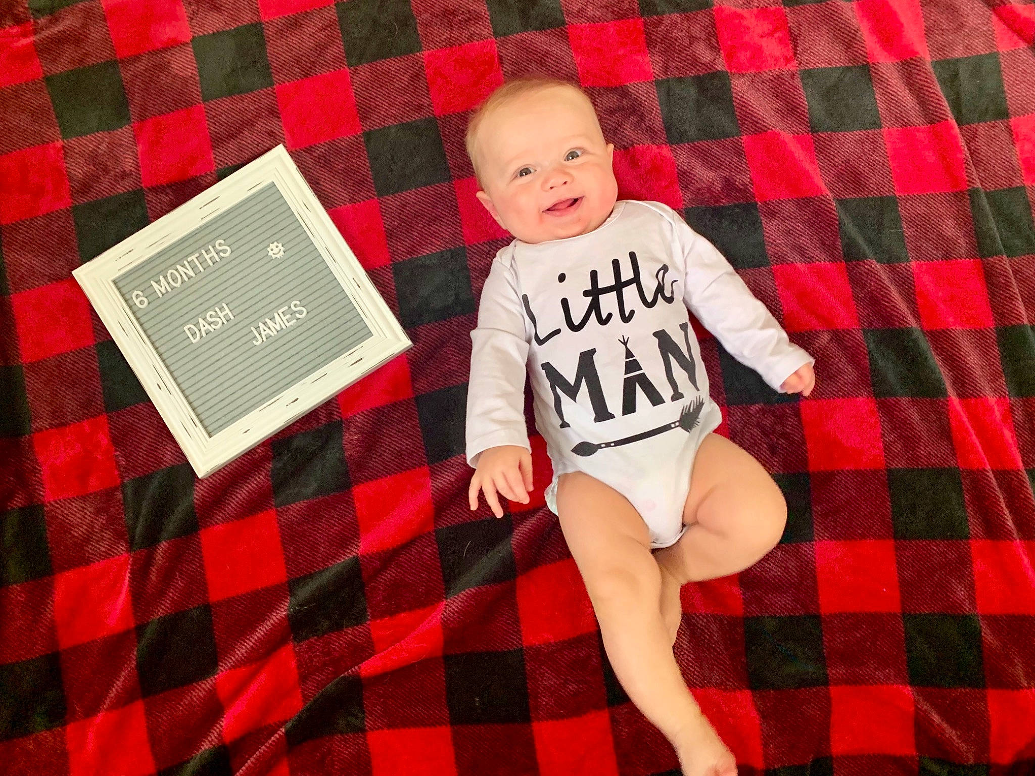 Dash is registered to the contest to win money with this photo: baby_toddler_clothing, child, design, font, linens, pattern, person, plaid, product, red, sleeve, t_shirt, tartan, textile, toddler