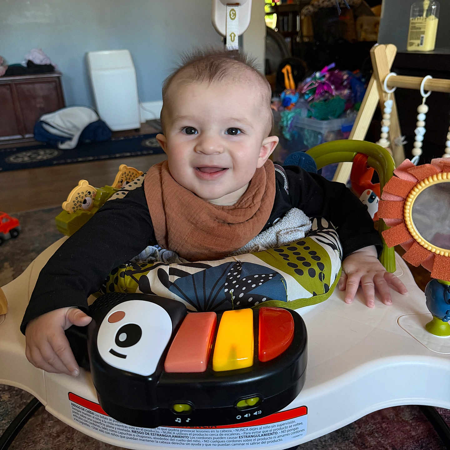 Arthur joined the competition — help win amazing prizes! baby, child, smile, piano, toy, activity_center, indoor, colorful, face, clothing, hand, floor, carpet, furniture, playtime, infant, happy, living_room, footwear, baby_bib