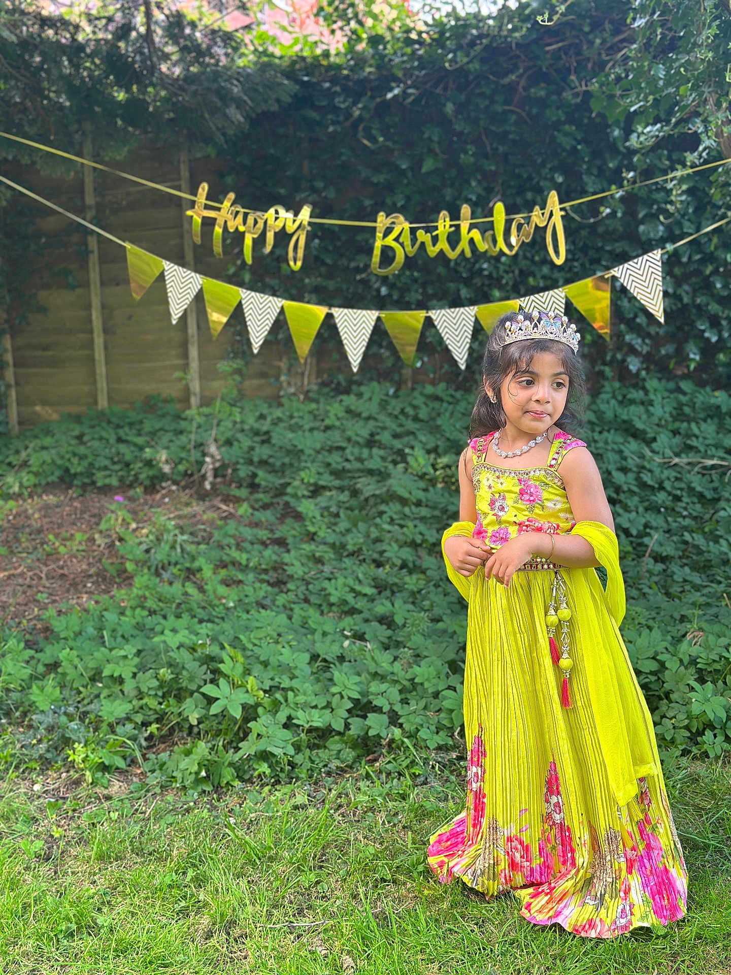 Tanvireddy is registered to the contest to win money with this photo: child, girl, birthday, party, tiara, dress, yellow_dress, pink_flowers, grass, garden, greenery, banner, happy_birthday, necklace, outdoor, celebration, festive, smiling, young, nature