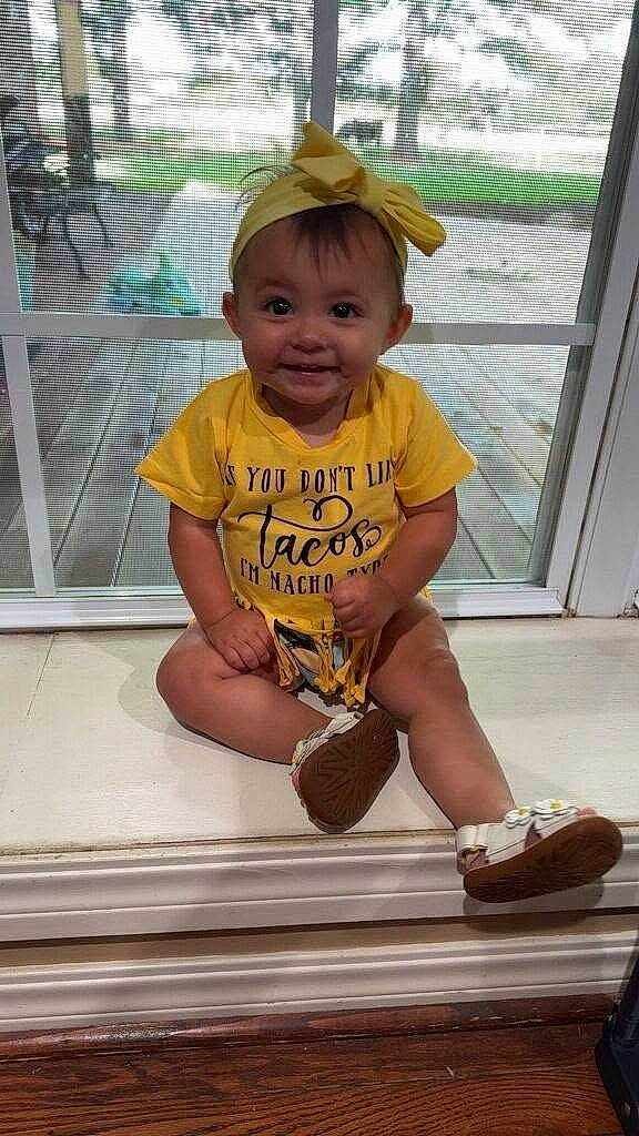 baby, casual, child, cute, door, face, happy, headband, indoors, playful, portrait, shoes, sitting, smiling, sunlight, toddler, window, wood_floor, yellow_clothing, young_child