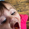 Michaela is registered to the contest to win money with this photo: child, baby, fork, food, mouth_open, eating, pink_shirt, wooden_floor, close_up, face, eye, hair, indoor, person, mealtime, appetite, cute, tongue, hand, dining