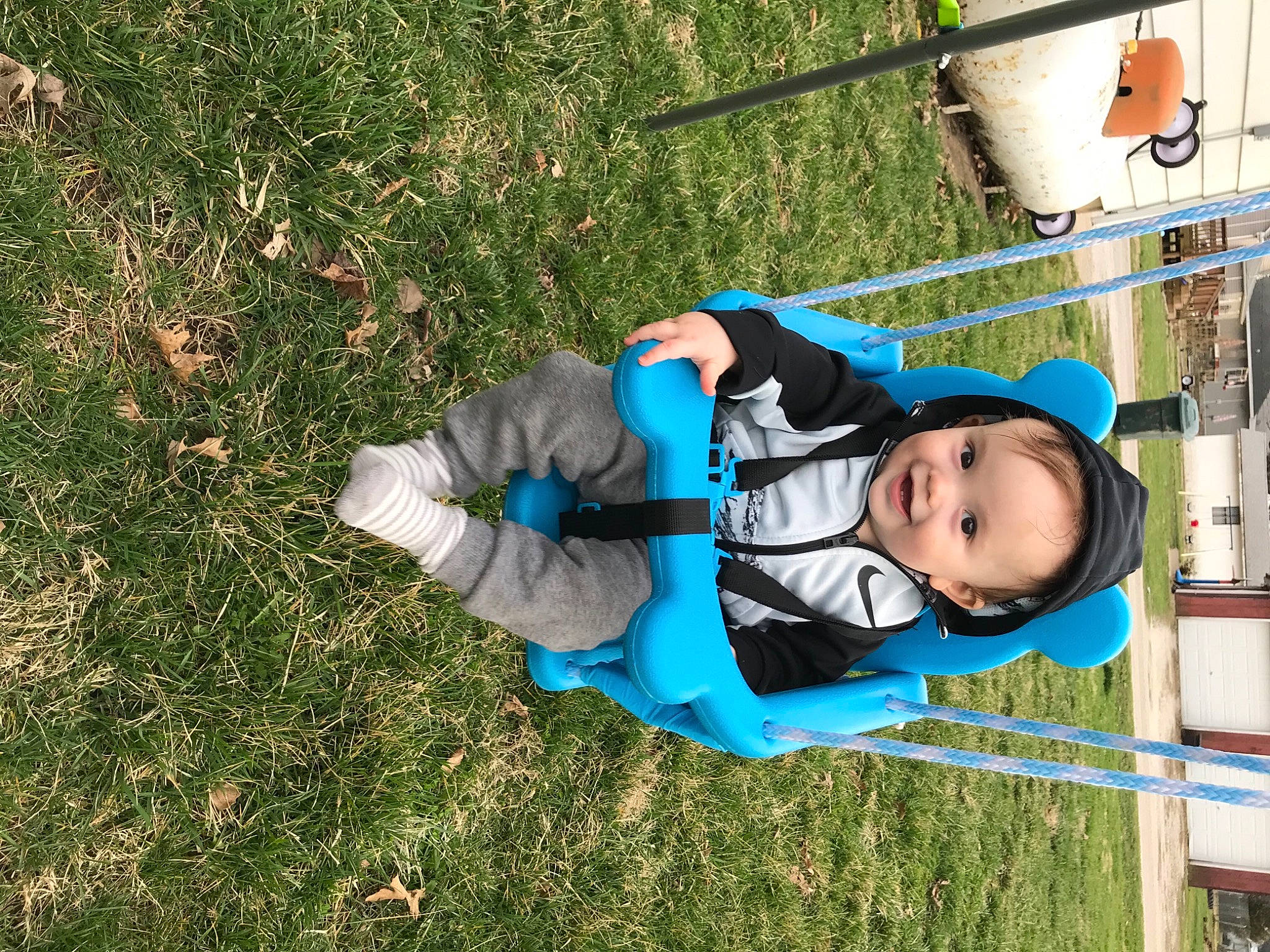 Colt is registered to the contest to win money with this photo: baby, baby_toddler_clothing, city, electric_blue, eye, fun, grass, grassland, groundcover, happy, jacket, joy, leisure, outdoor_play_equipment, people_in_nature, person, plant, playground, recreation, swing