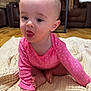 baby, child, infant, pink_clothing, polka_dot, blanket, floor, indoor, furniture, living_room, tongue_out, cute, sitting, crawling, head, face, human, skin, foot, hand