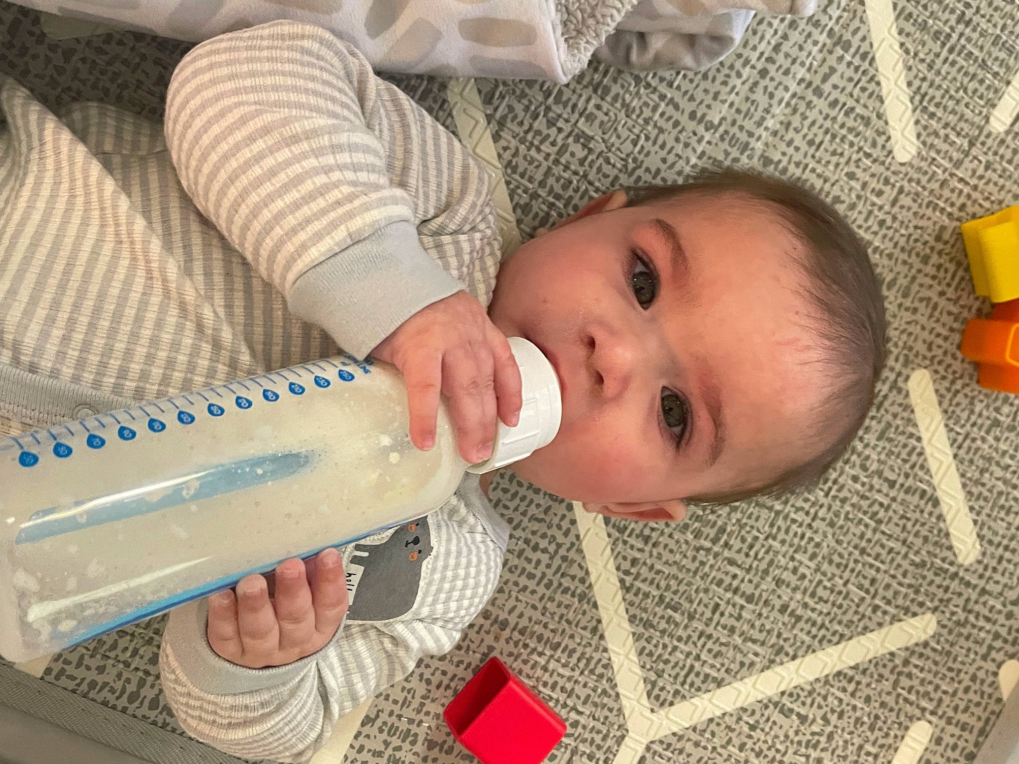 Aidan is registered to the contest to win money with this photo: baby, baby_bottle, baby_products, baby_safety, baby_toddler_clothing, bottle, child, comfort, drinkware, eyelash, hand, infant_formula, milk, nail, person, plant_milk, plastic_bottle, skin, smile, toddler