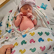 Octavia is registered to the contest to win money with this photo: newborn, baby, sleeping, blanket, duck_pattern, hat, bow, hand, finger, hospital, diaper, pacifier, bed, soft, cute, infant, resting, tenderness, wrapped, cozy
