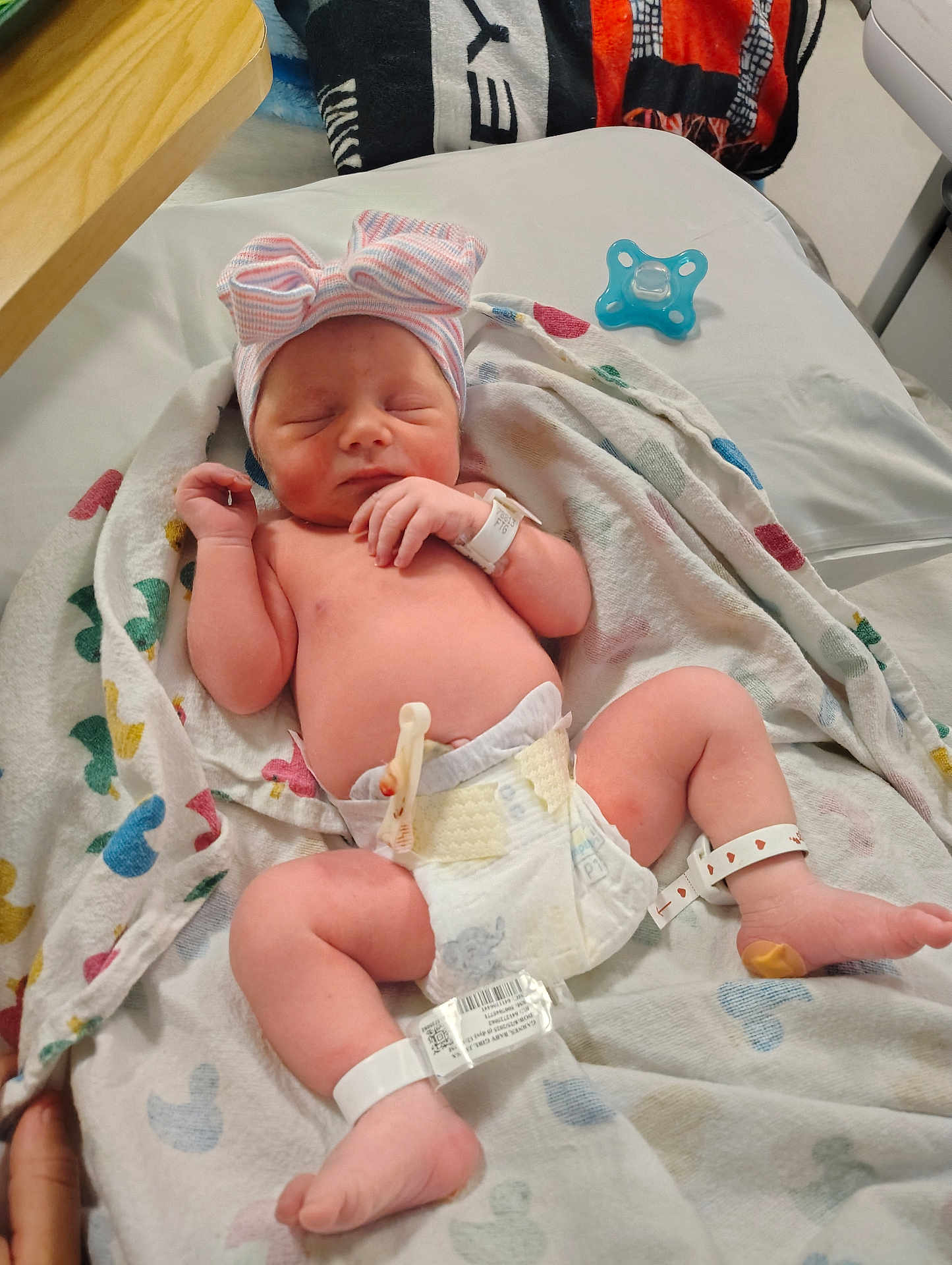 Octavia is registered to the contest to win money with this photo: newborn, baby, infant, hat, bow, diaper, blanket, hospital, wristband, pacifier, sleeping, cute, resting, child, human, skin, foot, hand, bed, person