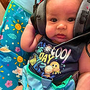 Ermias joined the competition — help win amazing prizes! baby, headset, infant, colorful, seat, pacifier, clothing, cute, expression, indoors, person, child, accessory, sitting, bright, patterned, young, face, comfort, toy