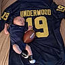 baby, infant, football, sports_jersey, clothing, blue, number_19, underwood, lying_down, small_football, baby_clothes, sock_shoes, bed, blanket, person, newborn, cute, sports_theme, indoor, resting