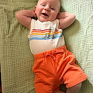 Philip joined the competition — help win amazing prizes! baby, barefoot, blanket, child, clothing, cute, dinosaur_print, green_blanket, happy, indoors, infant, lying_down, orange_shorts, portrait, relaxed, shorts, skin, smiling, striped_shirt, tank_top