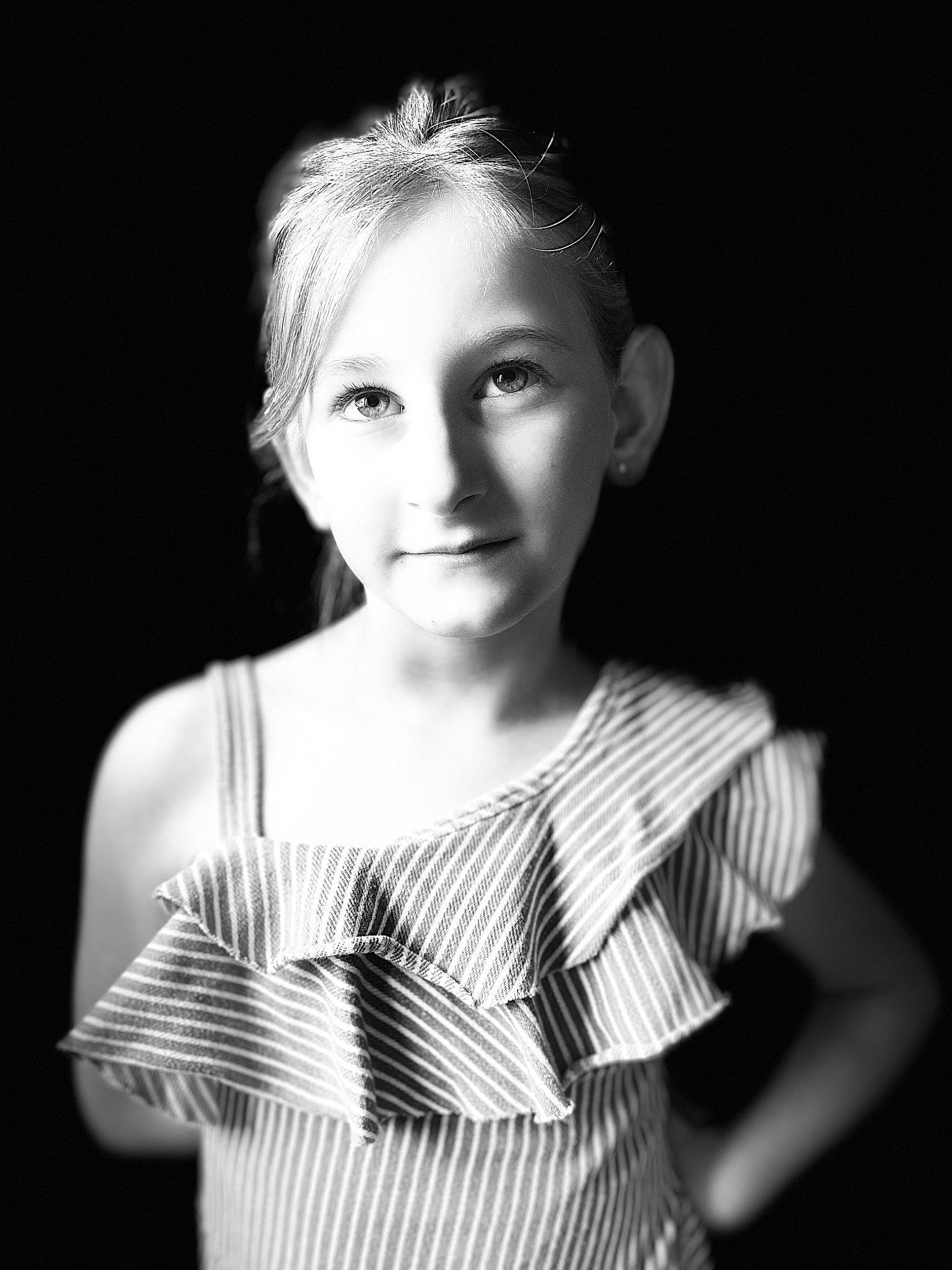 Tia participe au concours pour gagner de l'argent avec cette photo : black_and_white, child, darkness, day_dress, eyelash, fashion_design, flash_photography, gesture, hair, jaw, lip, monochrome, monochrome_photography, neck, pattern, people, person, plaid, shoulder, sleeve