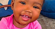 Jaziriah joined the competition — help win amazing prizes! toddler, child, smiling, baby, pink_shirt, hair_puffs, hand, holding_hands, indoor, carpet, sofa, portrait, cute, happy, person, skin, face, young_child, seated, closeup