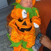 Layton joined the competition — help win amazing prizes! adult, baby, carpet, child, costume, cute, decor, festive, floor, green, halloween, hand, holiday, indoor, infant, orange, person, pumpkin, sleeping, sweater