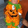 baby, child, costume, pumpkin, halloween, orange, green, sleeping, infant, person, hand, adult, sweater, indoor, floor, carpet, decor, cute, festive, holiday