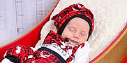 Layton is registered to the contest to win money with this photo: baby, sleeping, infant, plaid_clothing, red_clothing, black_clothing, white_clothing, reindeer_pattern, hat, blanket, sleigh_bed, cozy, holiday_theme, festive, soft_lighting, portrait, child, cute, indoor, peaceful