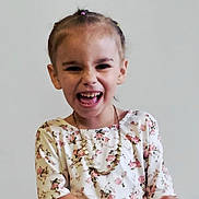 Charlie joined the competition — help win amazing prizes! child, girl, laughing, smiling, braided_hair, floral_dress, necklace, portrait, happy, cute, joyful, person, young, expression, hands, indoors, studio, light_background, emotion, fashion