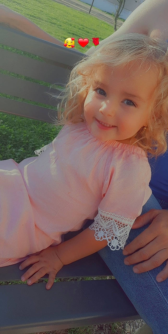 Inaya participe au concours pour gagner de l'argent avec cette photo : blond, dress, eye, eyelash, face, hair, happy, head, human_leg, iris, joy, knee, lip, long_hair, person, pink, skin, smile, thigh, toddler