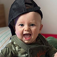 Aaron participe au concours pour gagner de l'argent avec cette photo : baby, child, smiling, face, cap, hat, clothing, camouflage, indoor, portrait, happy, cute, person, sitting, expression, young_child, headwear, mouth_open, eyes, baby_clothes