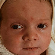 Kennedy is registered to the contest to win money with this photo: baby, infant, face, close_up, blanket, hood, skin, eyes, expression, newborn, soft_texture, portrait, child, young, head, warm_lighting, cute, person, indoors, wrapped