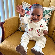 Carmyn joined the competition — help win amazing prizes! baby, child, smiling, waving, armchair, yellow_chair, white_clothing, cherry_pattern, cushion, indoor, portrait, happy, cute, footwear, sitting, person, home, floor_rug, natural_light, wooden_armrest