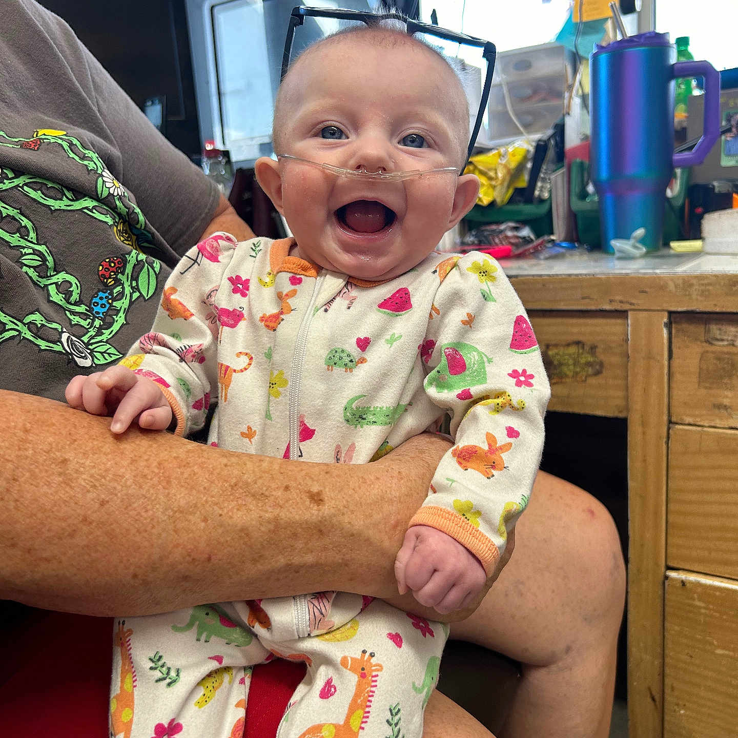 Berkeley is registered to the contest to win money with this photo: accessories, baby, clothing, computerhardware, diaper, electronics, face, furniture, glasses, happy, hardware, head, indoors, laughing, monitor, pajamas, person, photography, portrait, screen