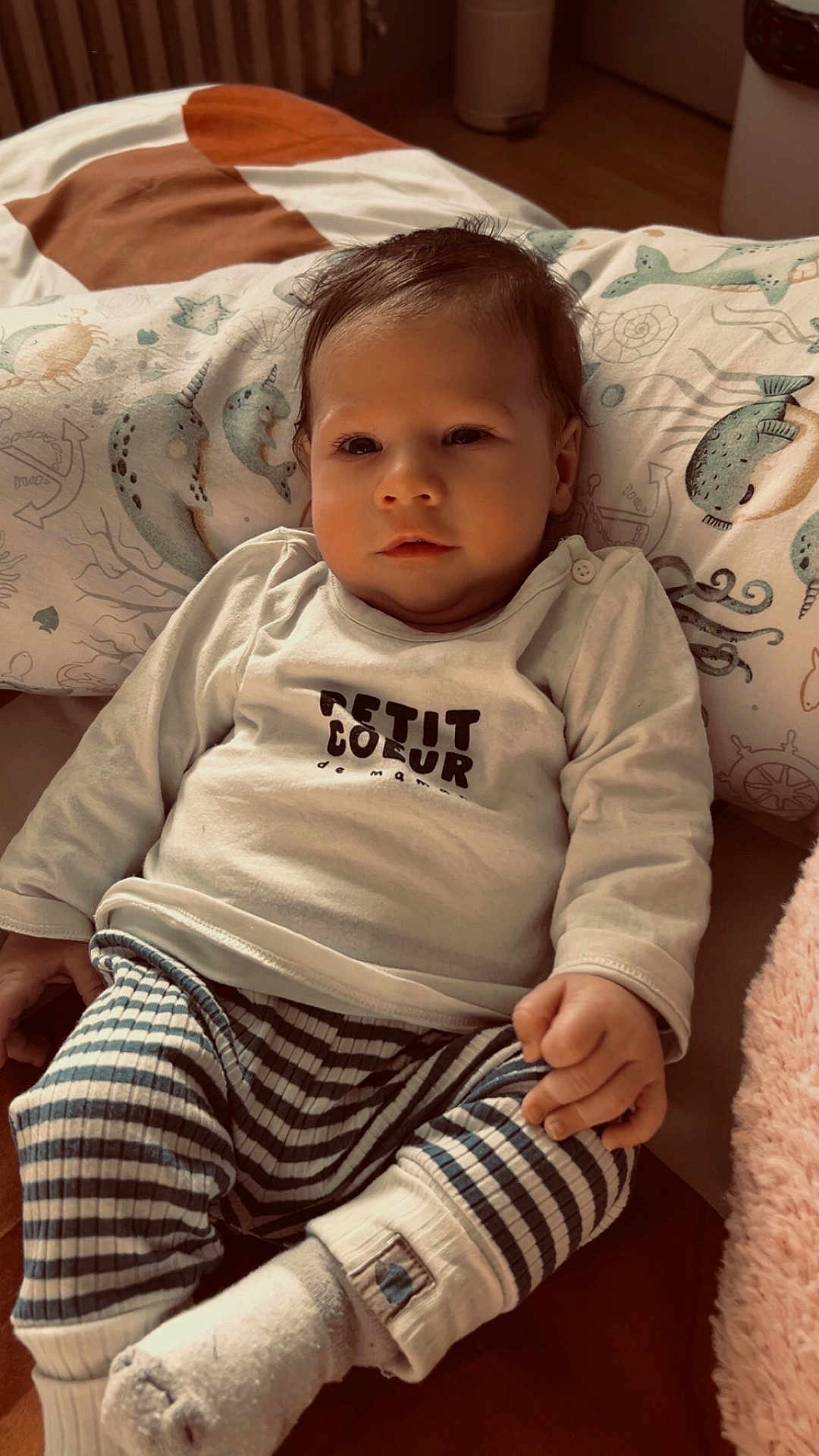 Mayann a rejoint le concours — aidez-le/la à gagner de superbes lots ! baby, infant, child, pillow, bedding, onesie, striped_pants, sock, hand, face, eyes, hair, portrait, soft_lighting, indoors, cute, cozy, nautical_pattern, sleepy, cuddly