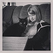 Pepsi Gerald is registered to the contest to win money with this photo: animal, black_and_white, black_cat, casual, cat, companion, couch, cozy, expression, furniture, girl, home, indoor, long_hair, looking, pet, portrait, relaxed, sitting, table