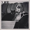 animal, black_and_white, black_cat, casual, cat, companion, couch, cozy, expression, furniture, girl, home, indoor, long_hair, looking, pet, portrait, relaxed, sitting, table