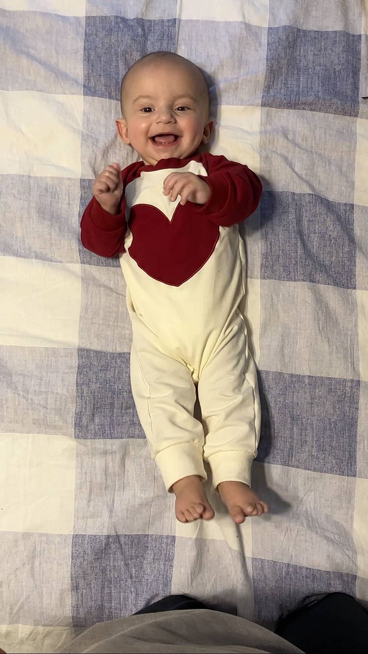 Paul is registered to the contest to win money with this photo: baby, babylaughing, bodypart, clothing, face, finger, hand, happy, head, homedecor, laughing, longsleeve, pants, person, photography, portrait, sitting, sleeve, smile, standing