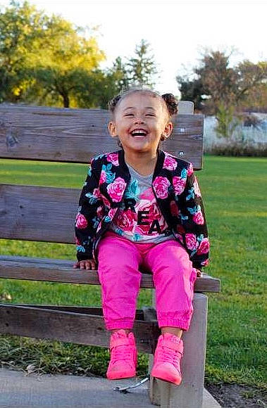 Skilar is registered to the contest to win money with this photo: child, day, footwear, fun, girl, grass, jeans, joy, outerwear, person, pink, plant, play, product, public_space, recreation, sitting, smile, standing, toddler