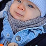 baby, child, face, blue_eyes, knit_hat, scarf, denim_jacket, baby_toy, pacifier_clip, soft_fabric, closeup, portrait, warm_clothing, infant, cute, smiling, baby_accessory, winter_wear, adorable, outdoor