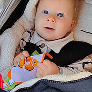 Mylo a rejoint le concours — aidez-le/la à gagner de superbes lots ! baby, infant, stroller, blanket, toy, blue_eyes, clothing, child, cute, face, hand, outdoor, soft_texture, warm, comfort, portrait, young_child, holding, striped_shirt, closeup