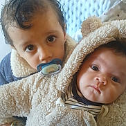 Soânn participe au concours pour gagner de l'argent avec cette photo : baby, bear_ears, blanket, child, coat, cuddly, curly_hair, cute, face, fluffy, hand, indoor, pacifier, person, portrait, siblings, soft_texture, striped_clothing, toddler, warm_clothing