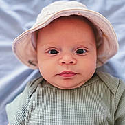 Malakai is registered to the contest to win money with this photo: baby, bonnet, cap, clothing, face, hat, head, hood, newborn, person, photography, portrait, sunhat